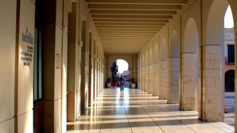 Sunlight and shadows along an arched walkway