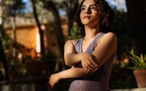 Woman gently holding her arm outdoors in natural light