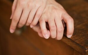 Hands resting on the edge of a wooden table