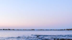 Gentle sea waves under a pale morning sky