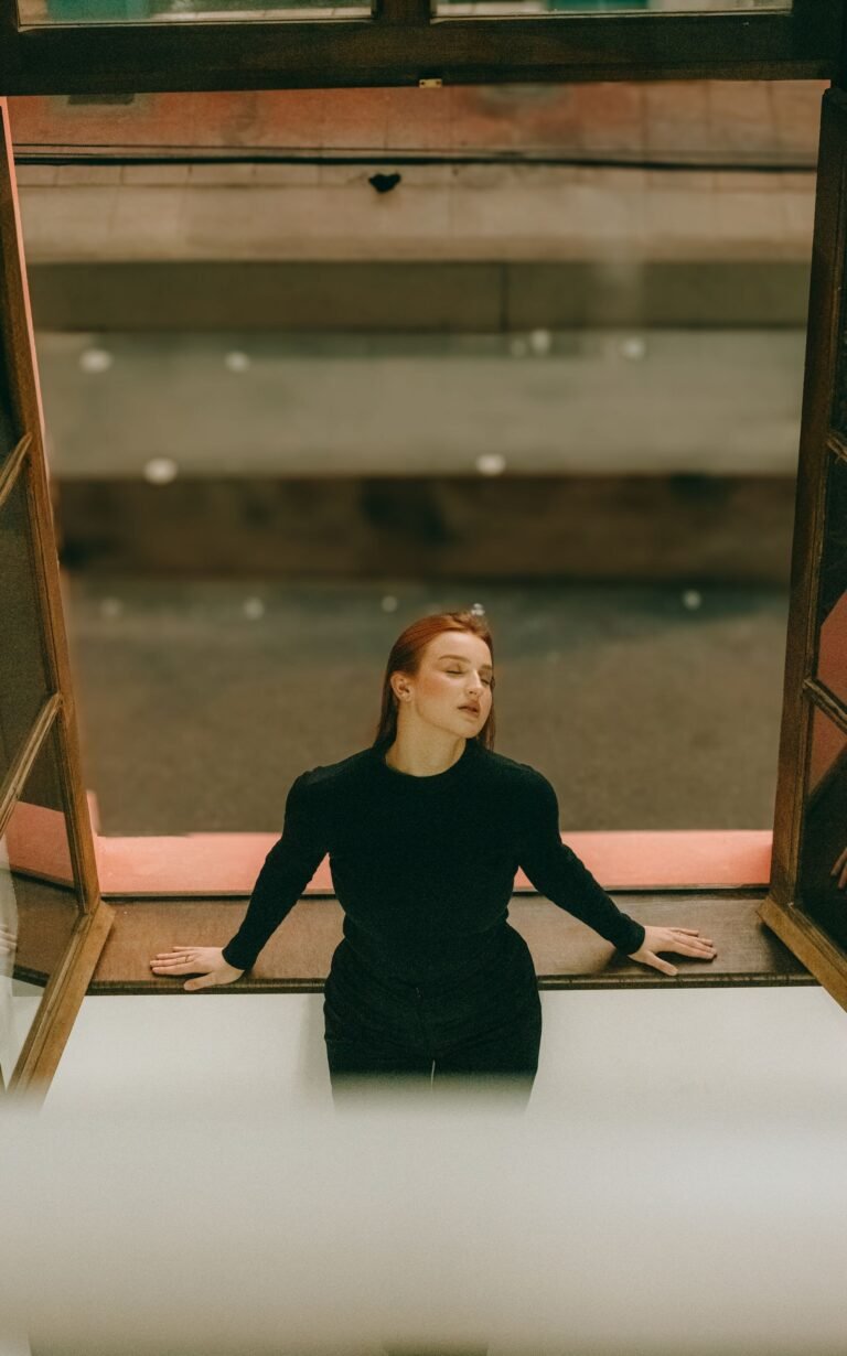 Woman taking a quiet moment at an open window