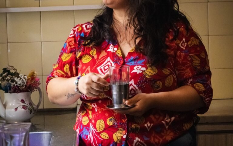 Woman holding a drink by a kitchen window