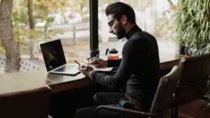 A person working at a laptop beside a cafe window