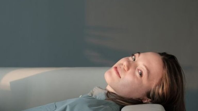 A person resting on a sofa in soft daylight