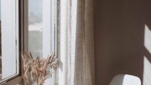 Sunlight falling on a white chair and curtain beside a window