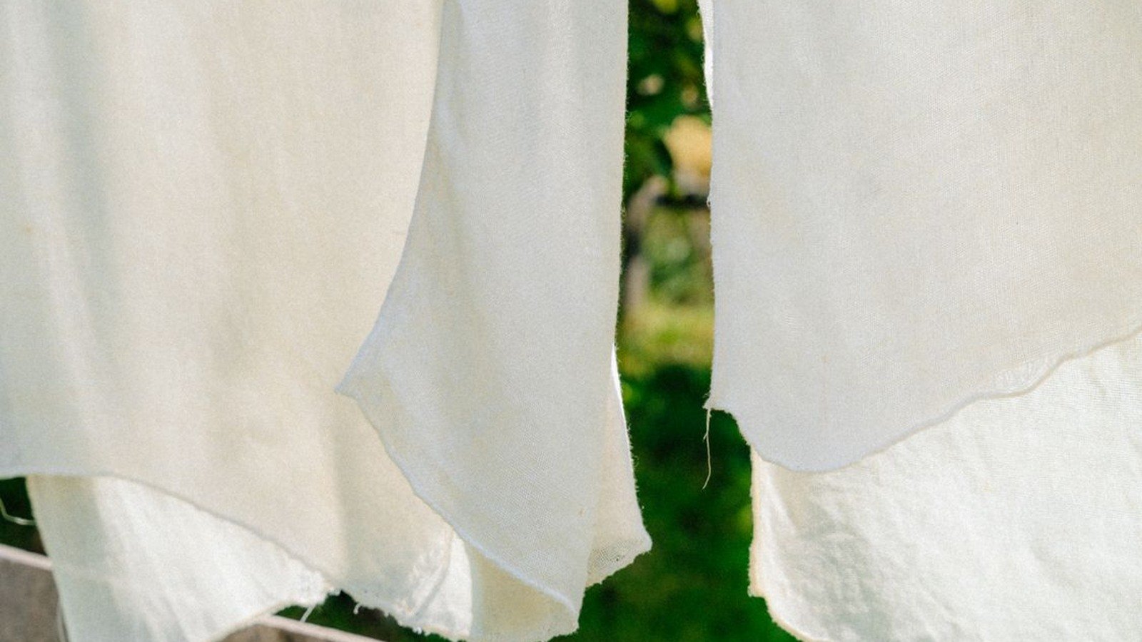 White natural fabric hanging in soft sunlight outdoors