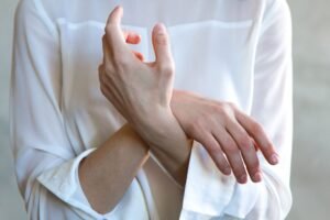Hands touching the forearm in natural light