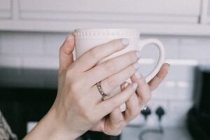 Hands holding a warm mug in a quiet kitchen